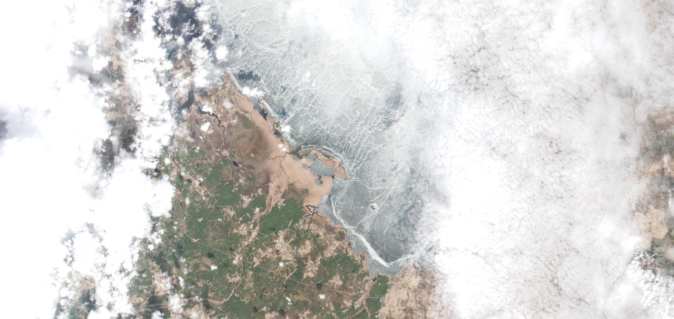 Märtsikuine RGB toonides satelliidipilt, mille keskmes on kuvatud jääkattega Pihkva järv ning kummalgi pool järve on näha pilvkatet.